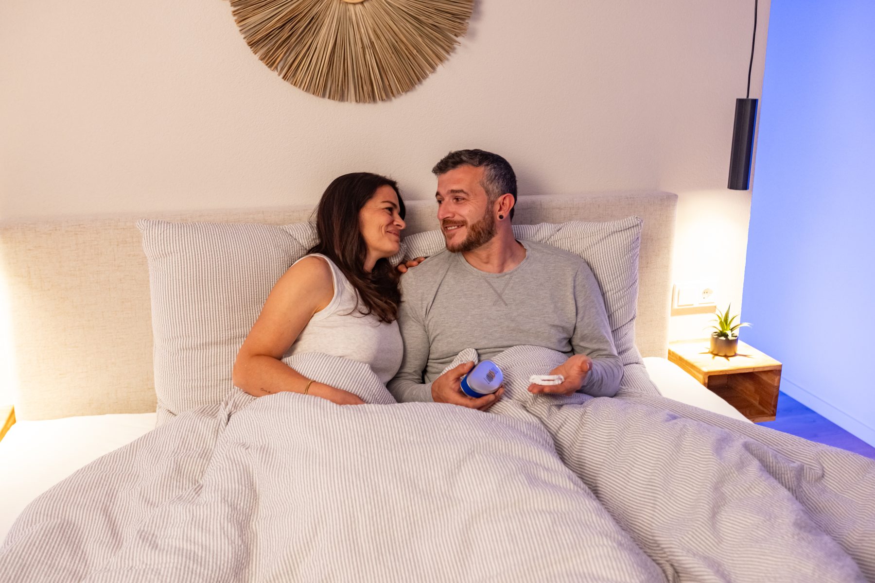 Darstellerpaar wach und entspannt nebeneinander im Bett, Schlüsselbild des LunaSol Werbespots zum gemeinsamen Schlaf