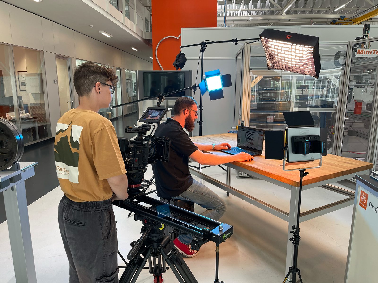 Making of beim MiniTec Imagefilm, RED Cinema 6K auf Motion Control Slider mit blauen und orangen RGB Lichtsetups vor einem Aluminium Profilrahmen Setup im Studio